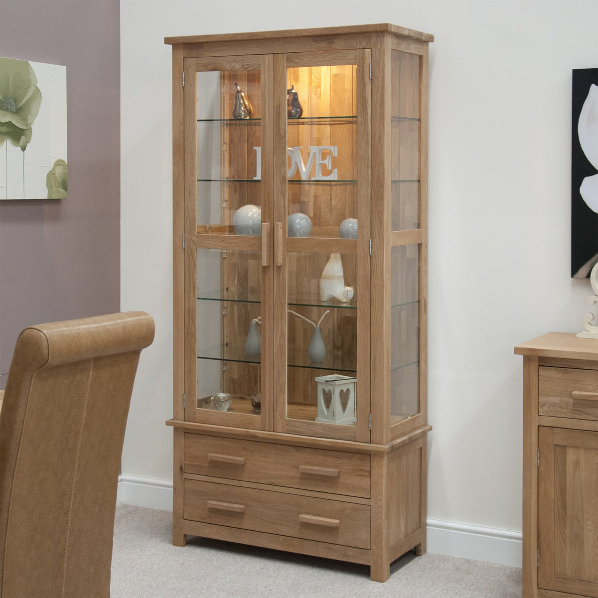 Oak display cabinet with glass doors and shelves, decorated with ornaments in living room
