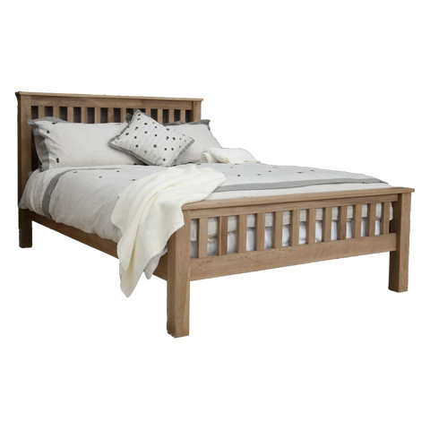 Oak wooden bed frame with slatted headboard and footboard, dressed with neutral bedding