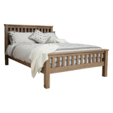 Oak wooden bed frame with slatted headboard and footboard, dressed with neutral bedding