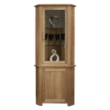 Oak corner display cabinet with glass door, wooden shelves, and decorative items inside