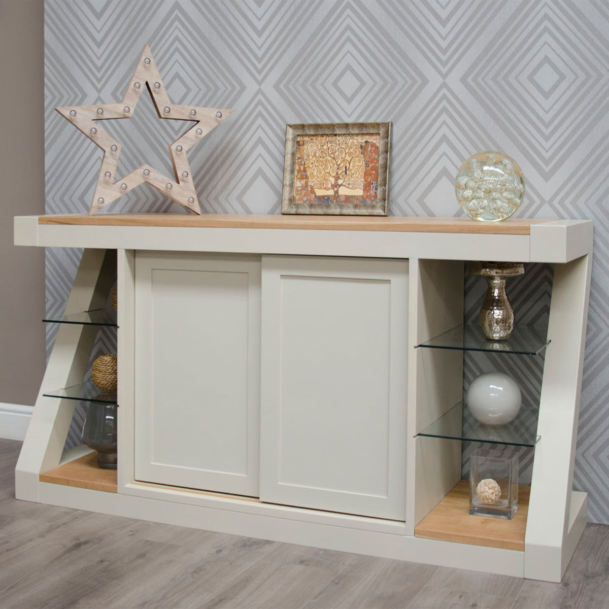 Modern cream sideboard with sliding doors and glass shelves, styled with decor accents