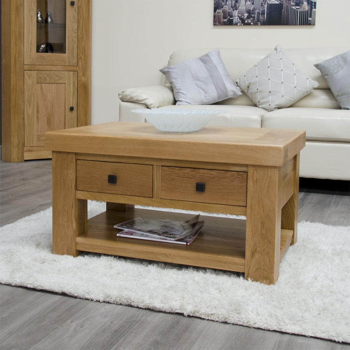 Oak coffee table with drawers and shelf on white rug in modern living room
