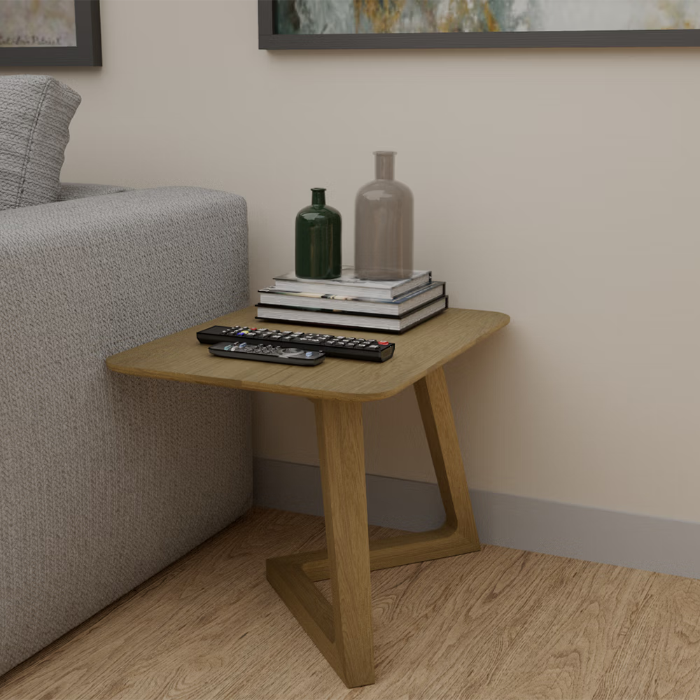 Oak side table beside sofa with books, vases, and TV remotes on top