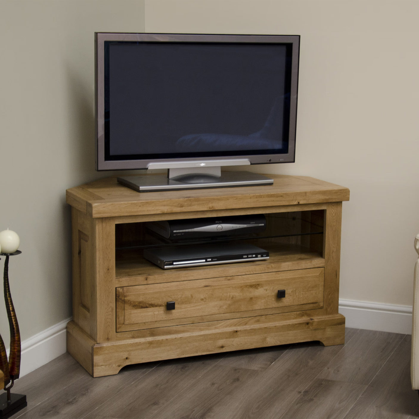 Oak TV unit with open shelf, glass panel and storage drawer on wood flooring