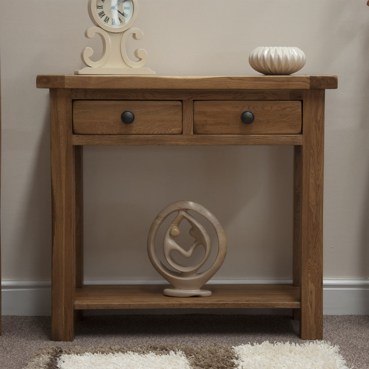 Oak console table with two drawers, decorative ceramics, and a modern sculpture on lower shelf