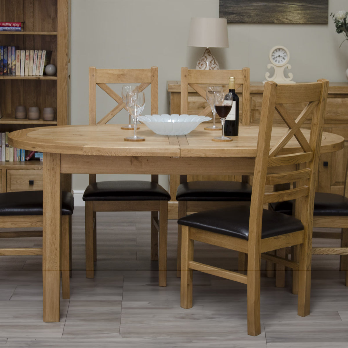 Oak dining table set with four chairs featuring black seat cushions in modern dining room