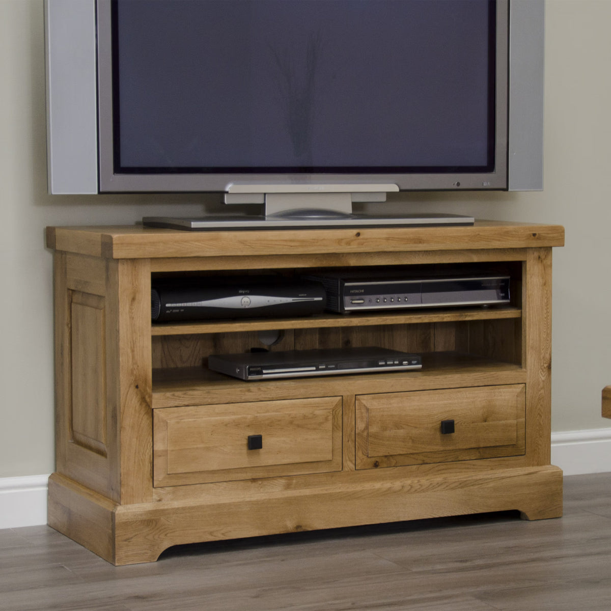 Oak TV unit with drawers and open shelves, holding flat screen television and electronics