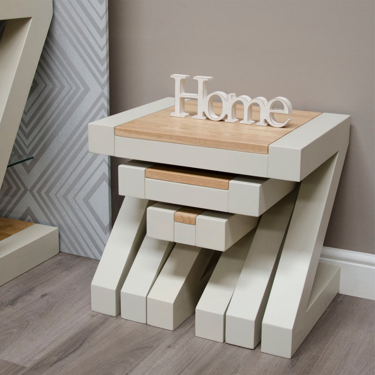 Cream and oak nesting tables with modern geometric legs on wood floor