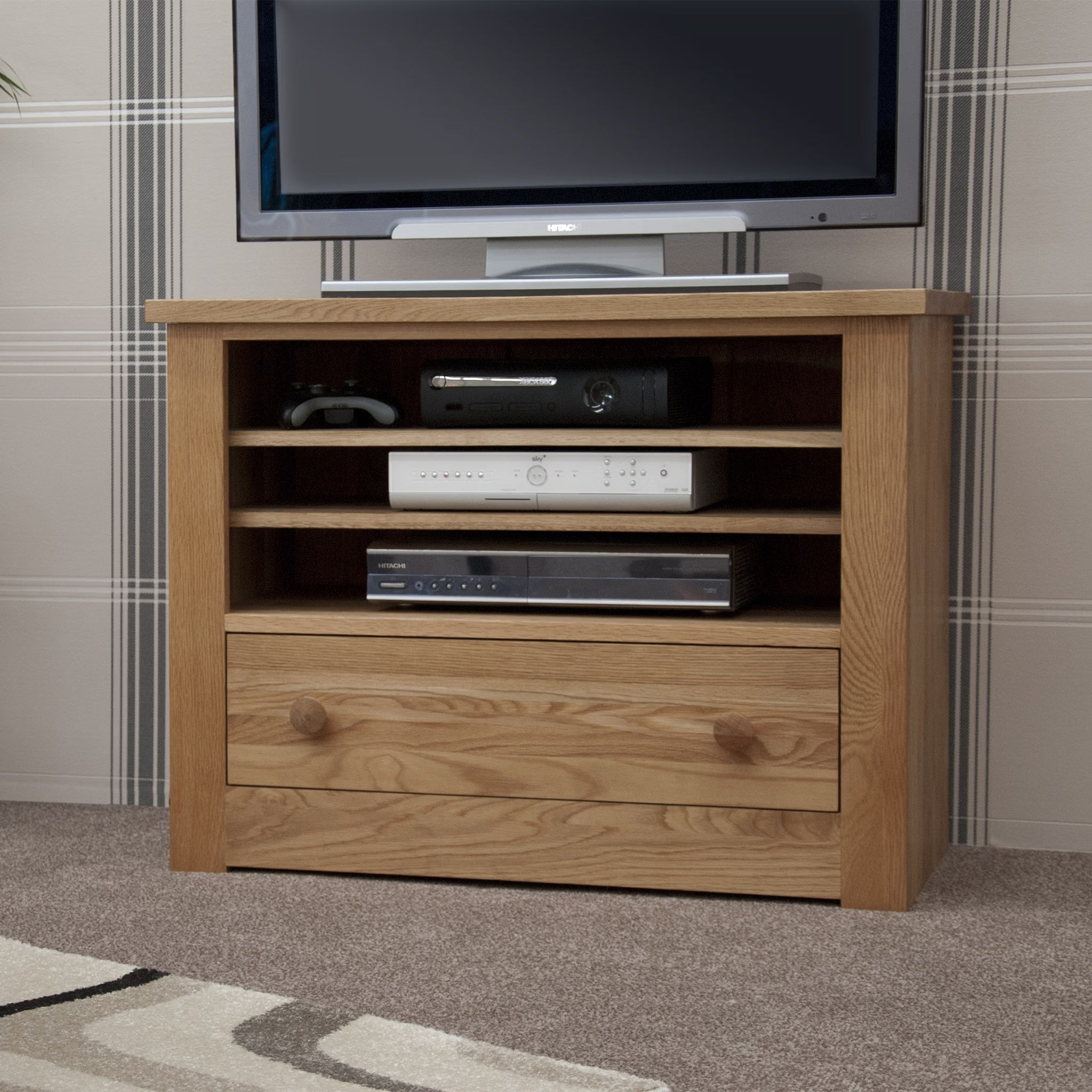 Oak TV unit with storage shelves and single drawer on carpeted living room floor