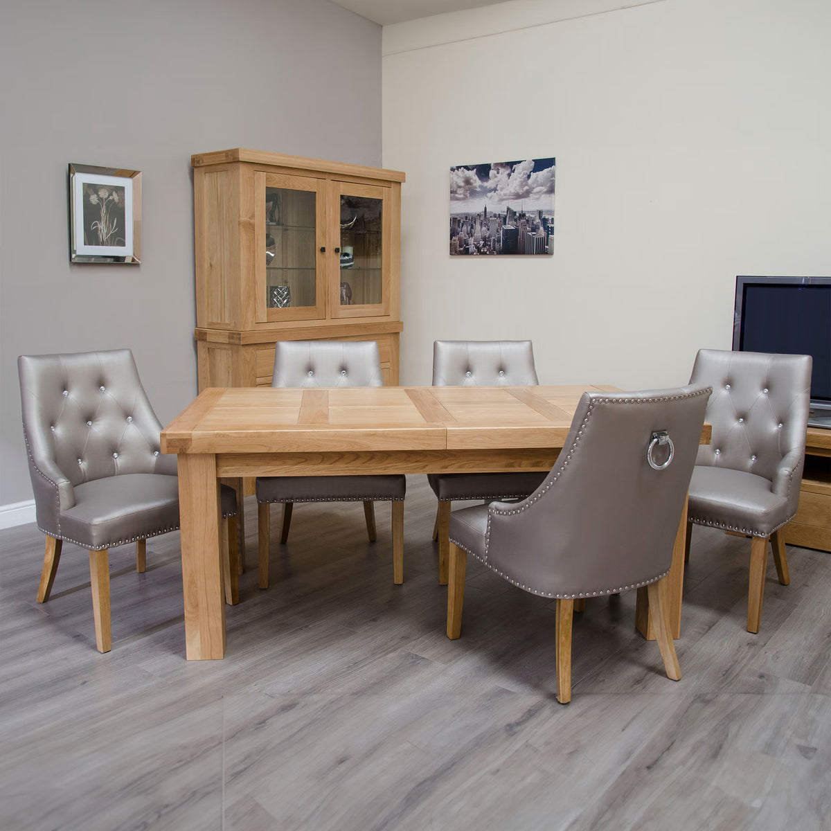 Oak dining table with six grey upholstered chairs in modern dining room setting