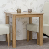 Oak dining table with two cream chairs and mugs on top, set on carpeted floor