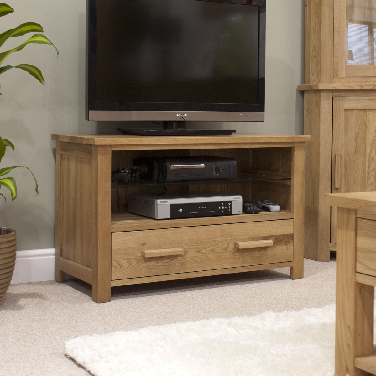 Oak TV unit with drawer and open shelf for media storage in living room setting