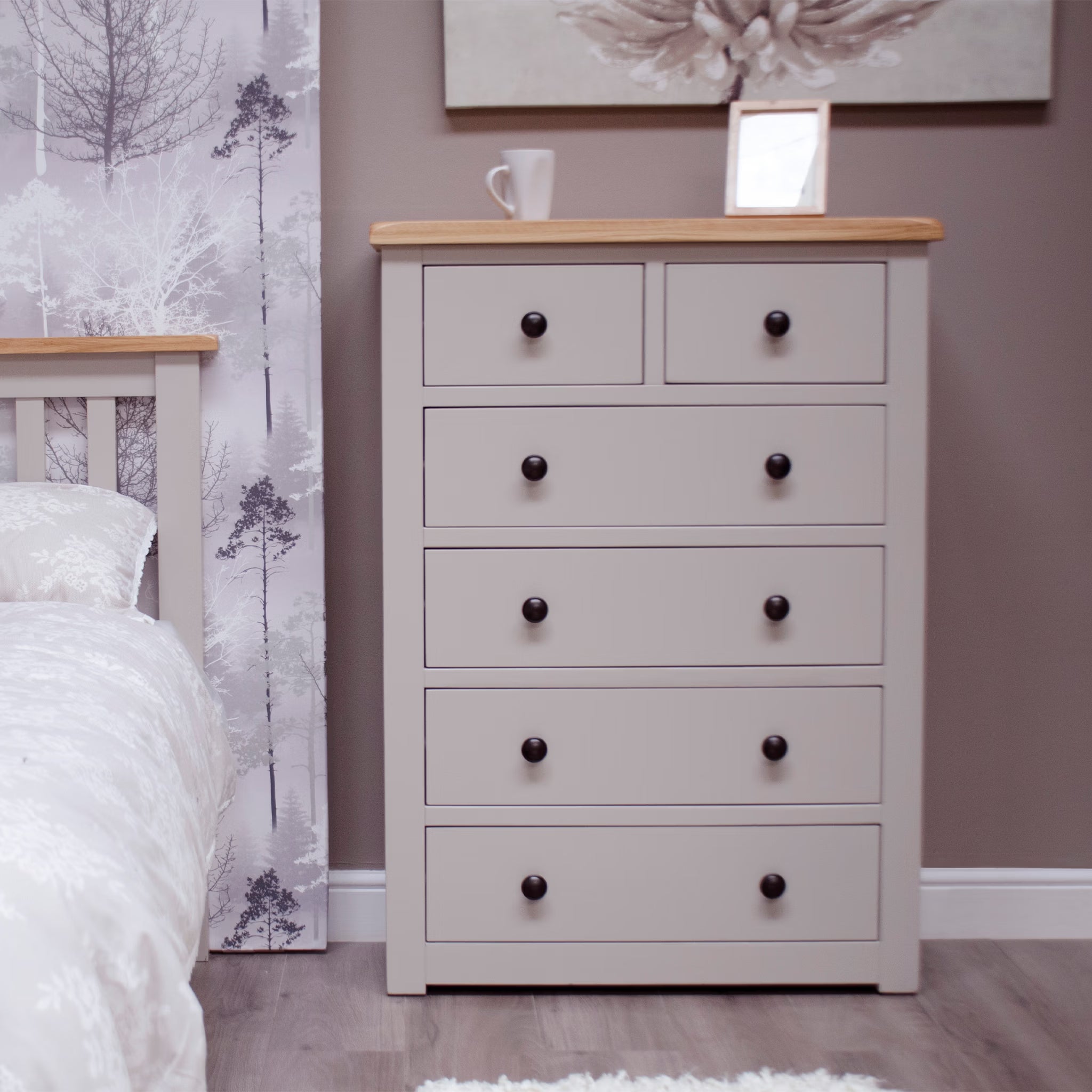 Grey chest of drawers with wooden top in bedroom, black knobs, six drawers, modern style