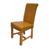 Tan leather dining chair with oak legs and high backrest, angled side view