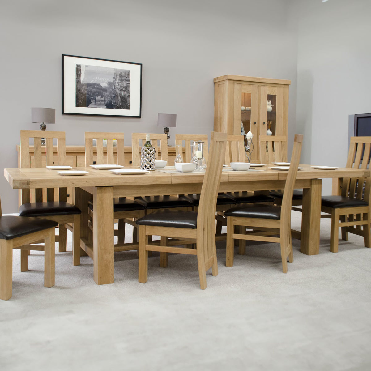 Solid oak dining table set with eight slatted chairs and black cushions in modern room