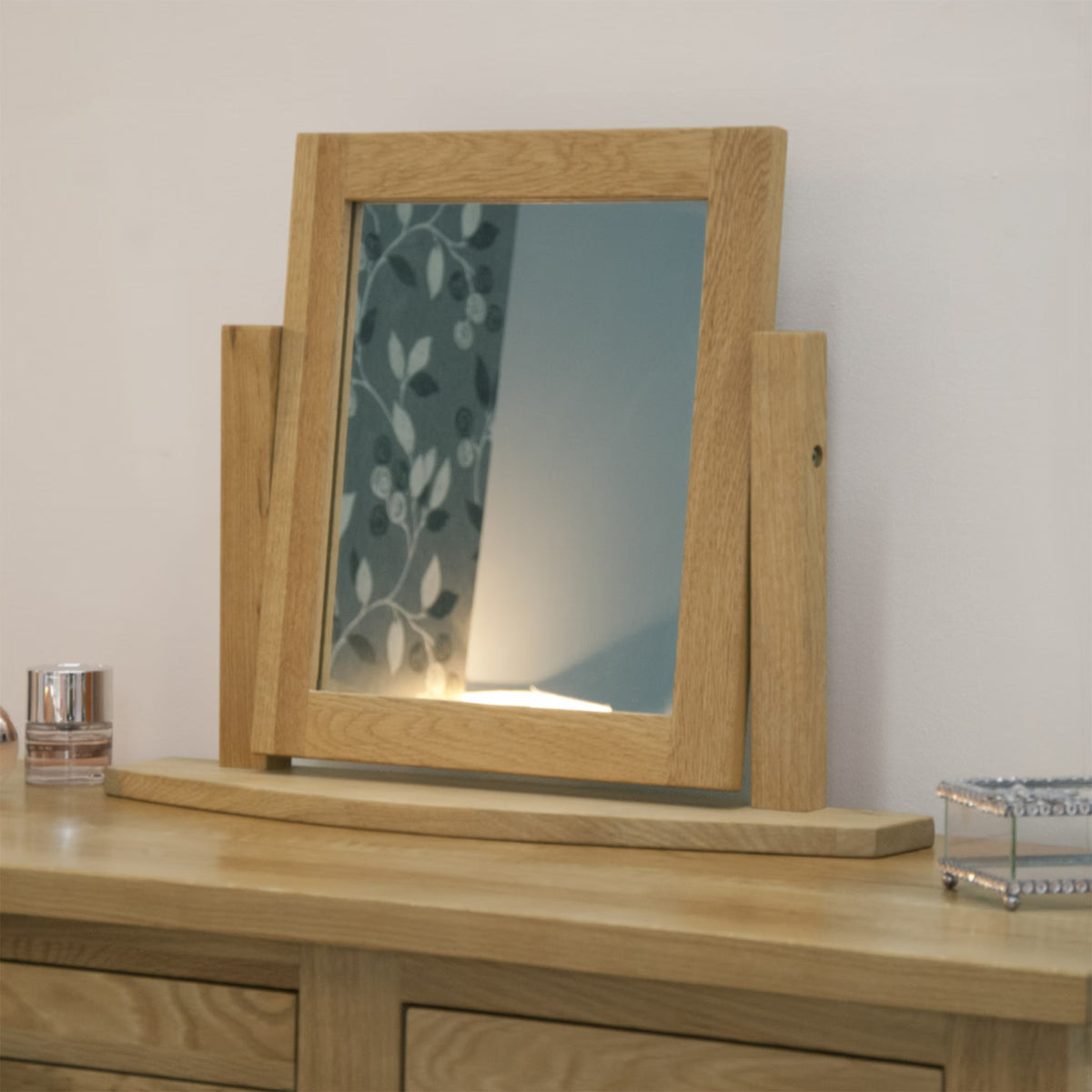Oak dressing table mirror with rectangular wooden frame on wooden dresser