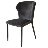 Black velvet dining chair with curved backrest and metal legs side view