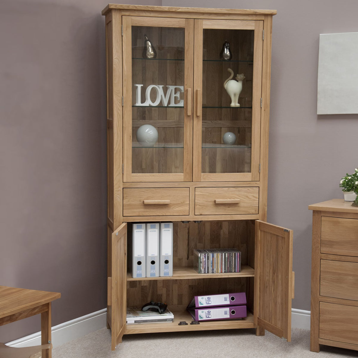 Oak display cabinet with glass doors, storage drawers and lower shelves holding files and binders