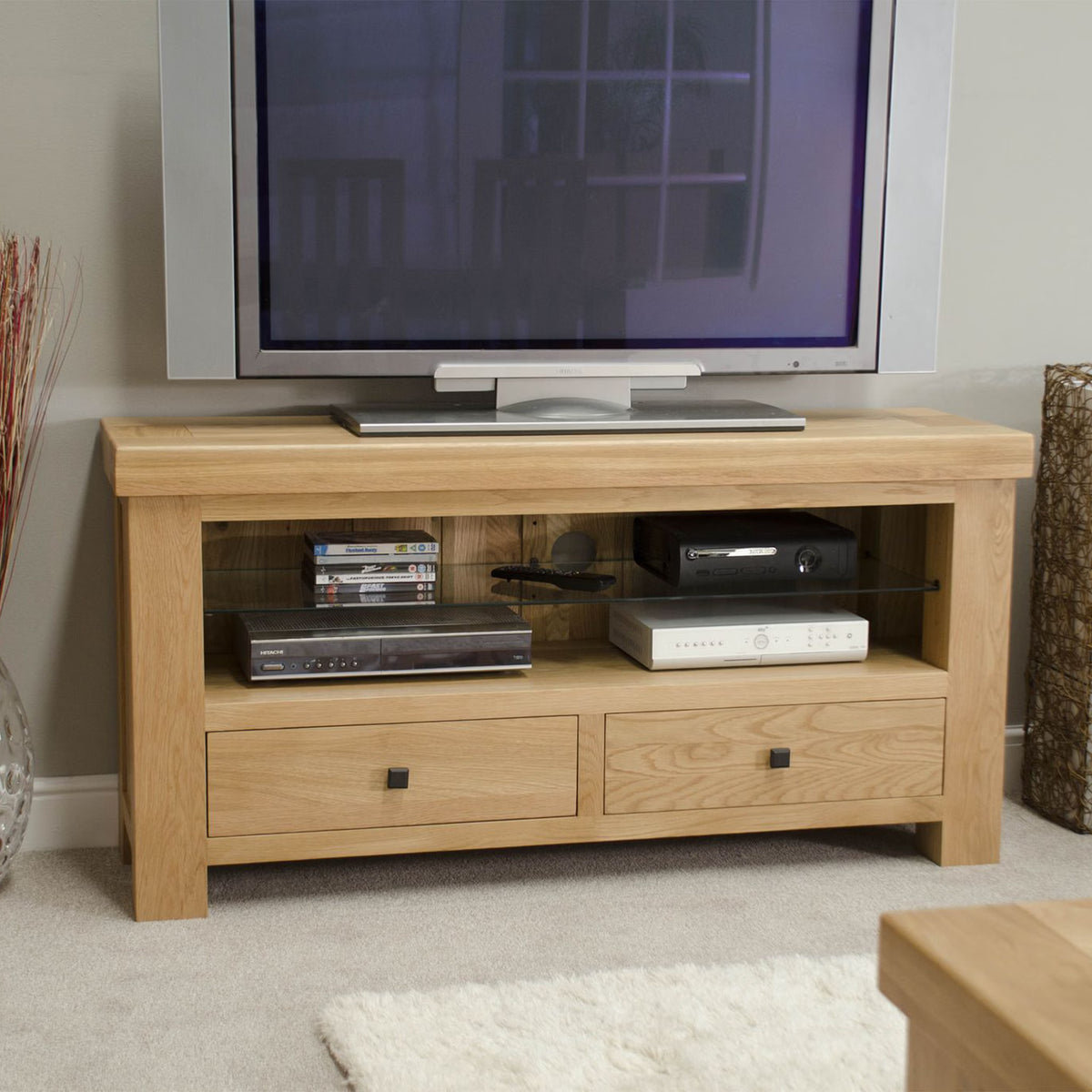 Oak TV unit with open shelves, storage drawers, and media devices in living room