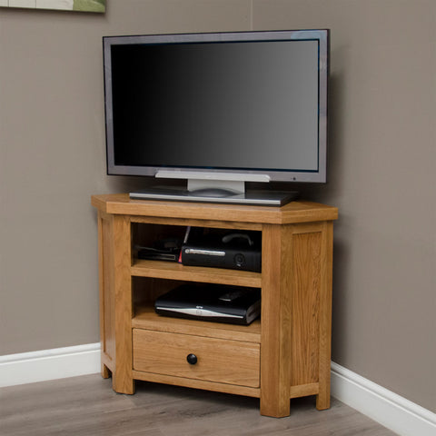 Oak corner TV unit with storage shelves and drawer in living room setting