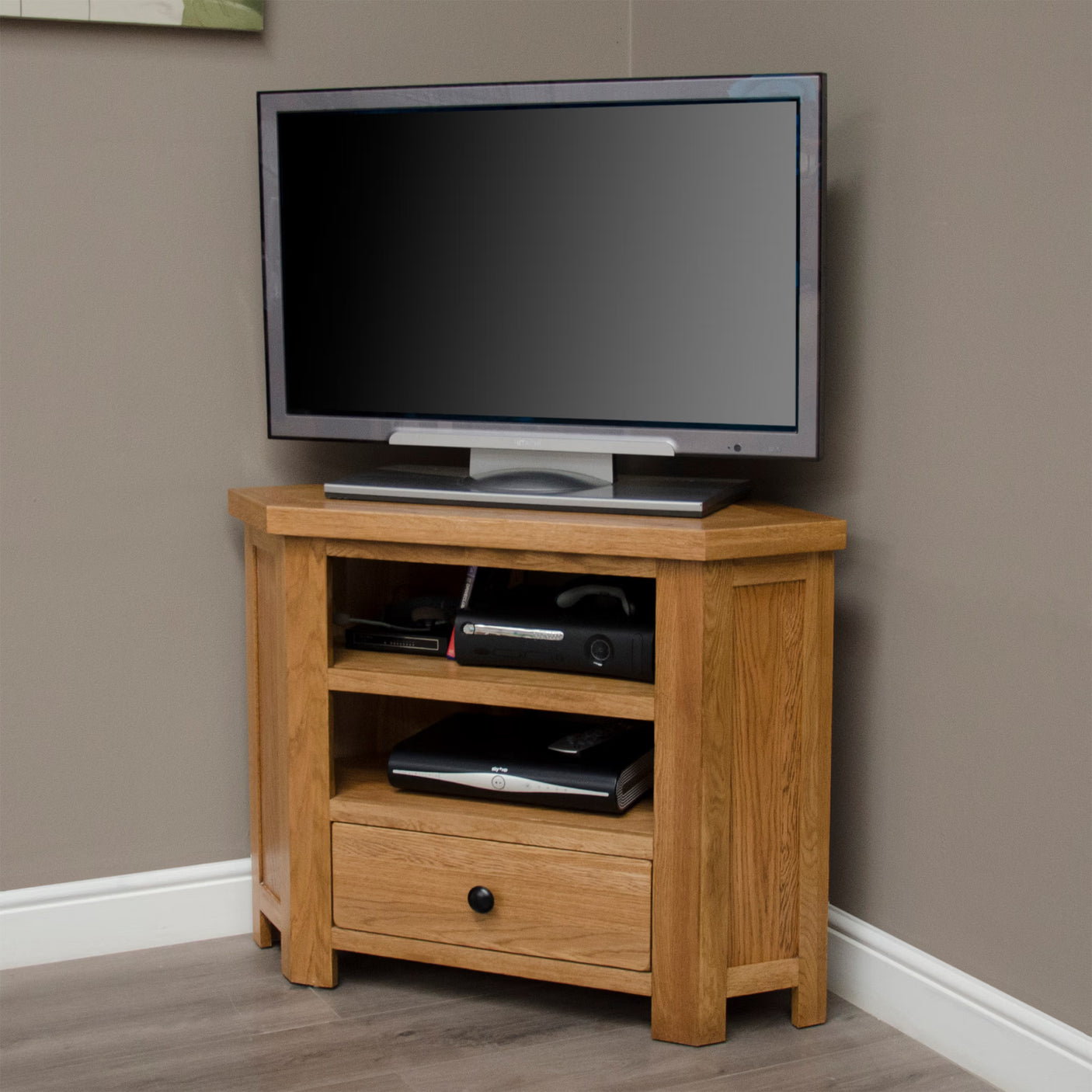 Oak corner TV unit with storage shelves and drawer in living room setting