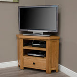 Oak corner TV unit with storage shelves and drawer in living room setting