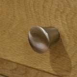 Brushed metal drawer handle on light oak wood furniture closeup