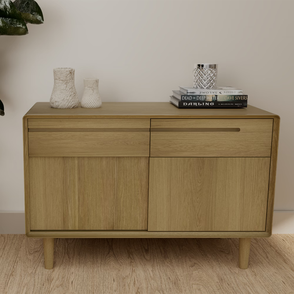 Light wood sideboard with two drawers and cabinet doors, decorated with vases and books
