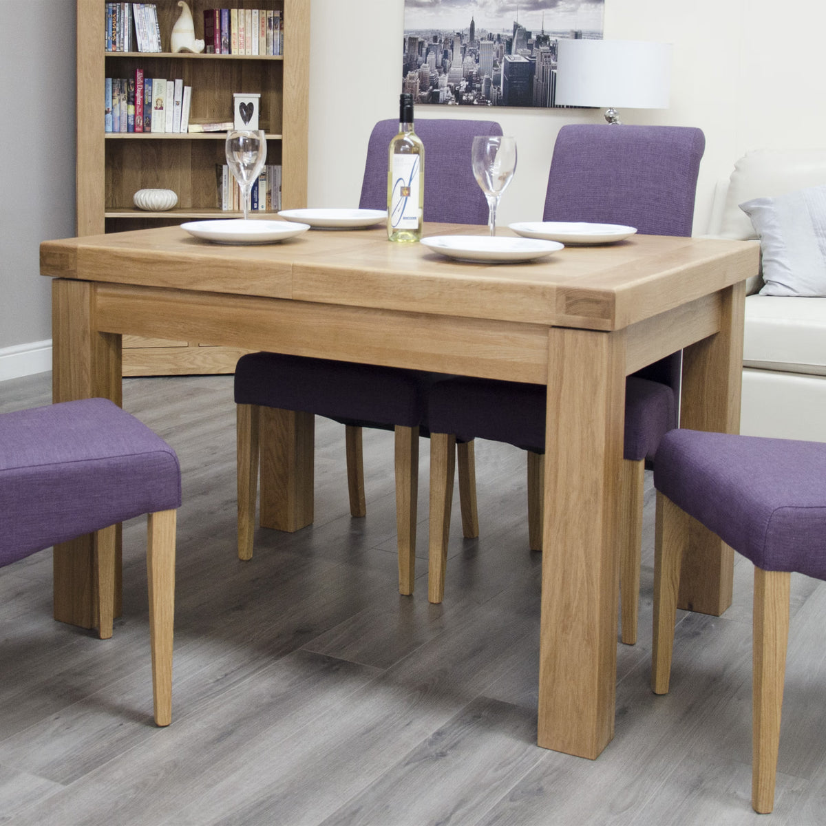 Oak dining table set with purple upholstered chairs in modern living room