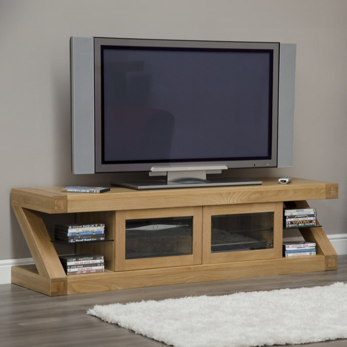 Oak TV unit with glass doors and open side shelves in modern living room setting