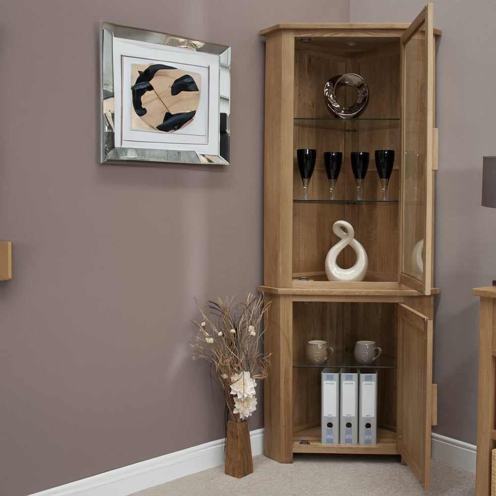Oak corner display cabinet with glass doors, shelves, and modern home decor items