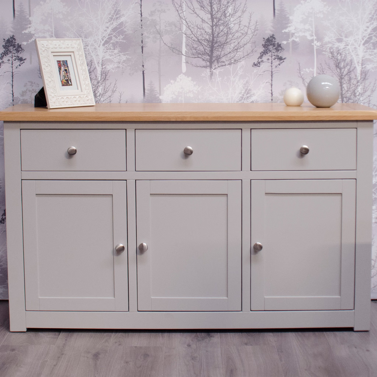 Grey sideboard with three drawers and oak top against woodland wallpaper, home decor accents