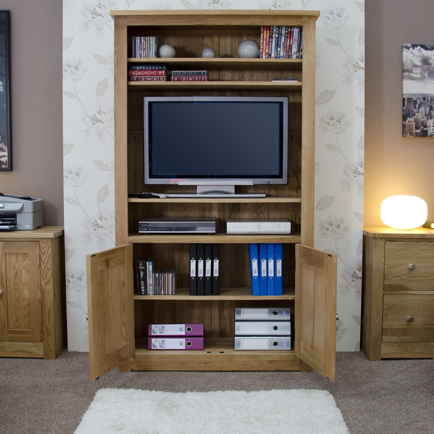 Oak TV unit with open shelves and cupboards, storing folders, DVDs and media devices