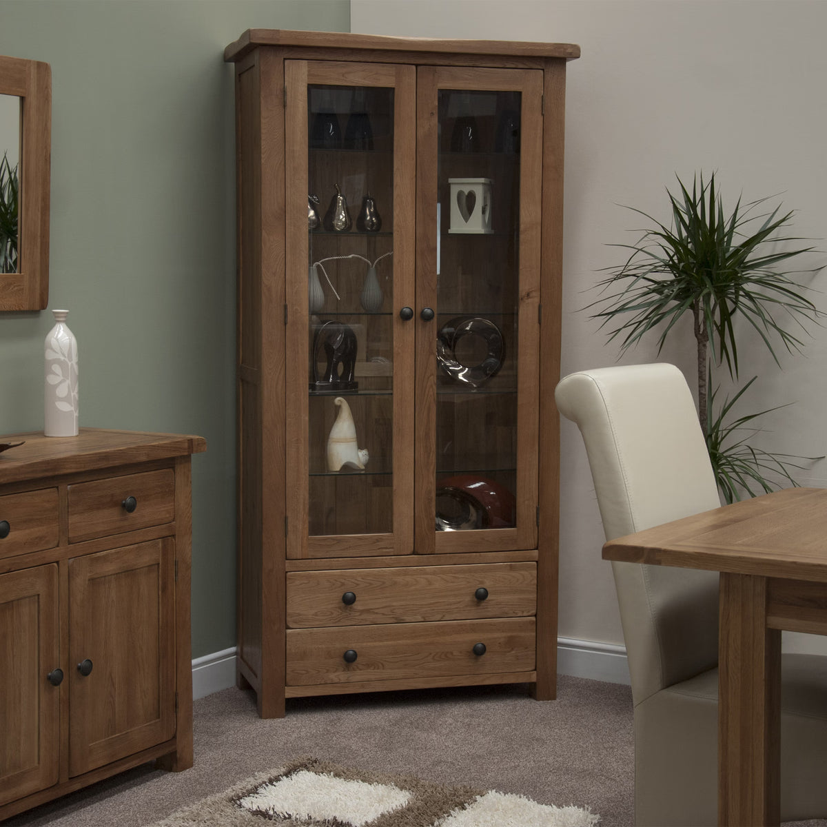 Oak display cabinet with glass doors and two drawers in modern dining room setting