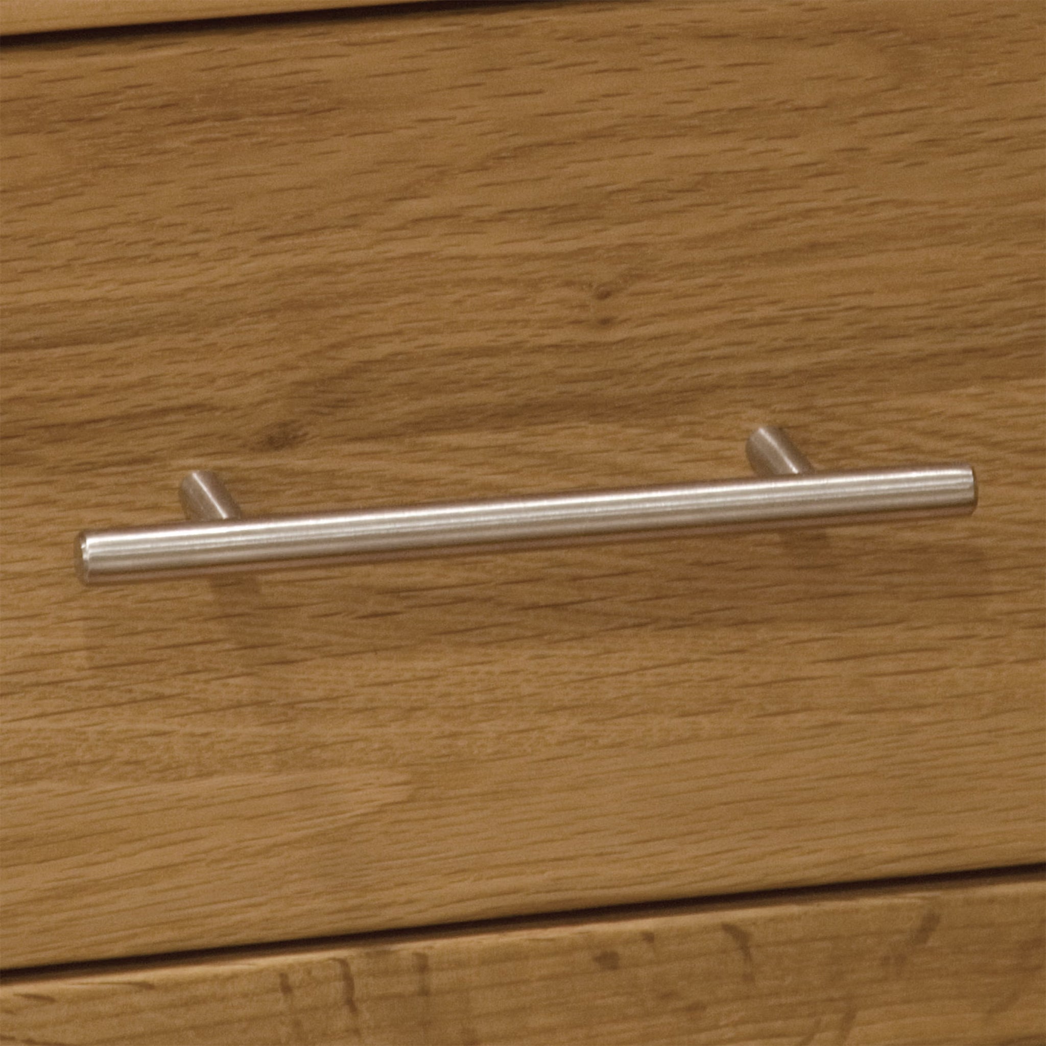 Oak drawer with brushed metal handle in close-up view
