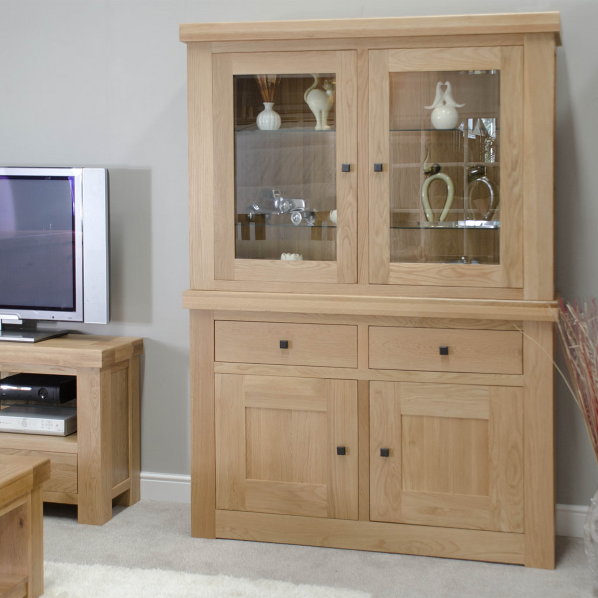 Oak display cabinet with glass doors and shelves in living room setting
