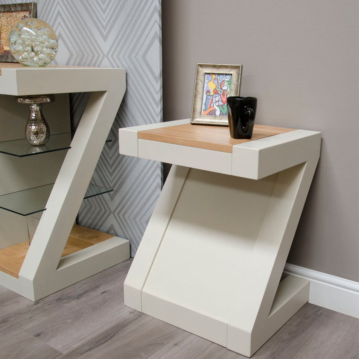 Cream Z-shaped side table with oak top, ceramic mug, and framed art on wood floor