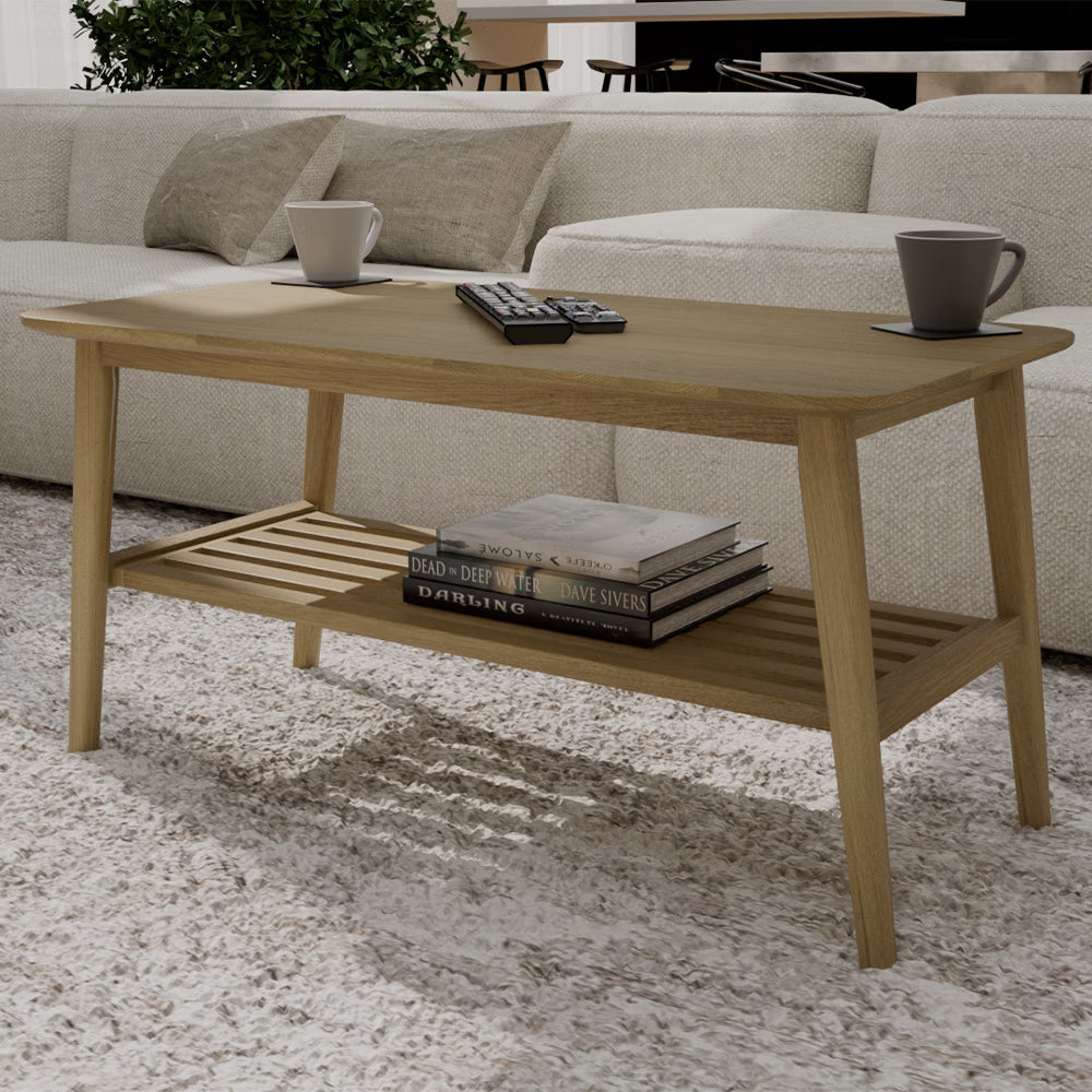 Rectangular oak coffee table with lower shelf, books and mugs in modern living room