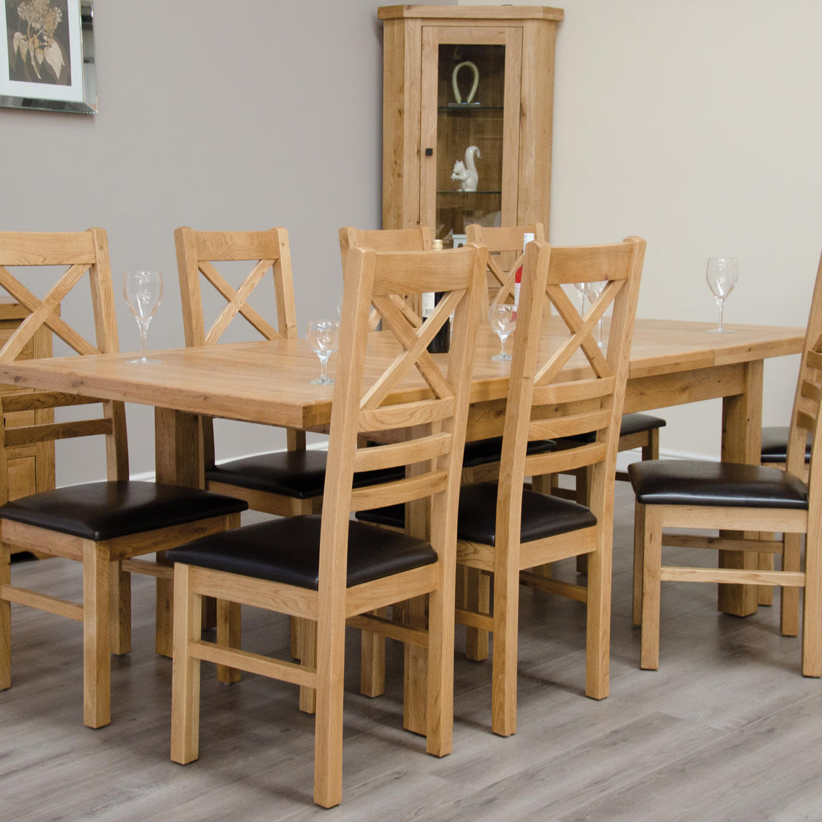 Oak dining table set with six chairs, black cushions, on wood floor in modern dining room