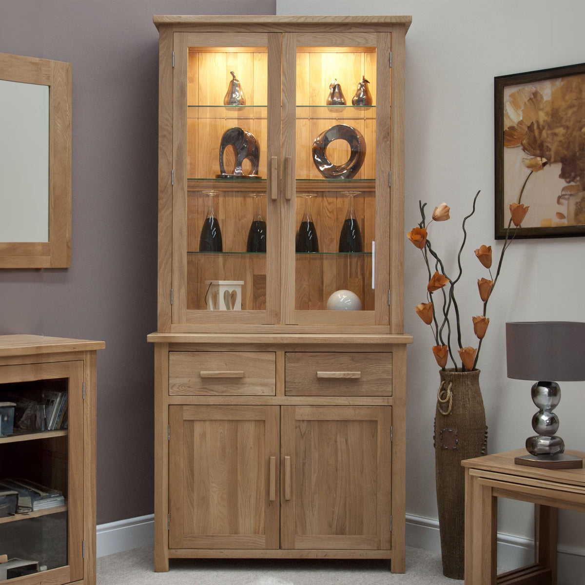 Oak display cabinet with glass doors, interior shelving and drawers, styled in a modern living room