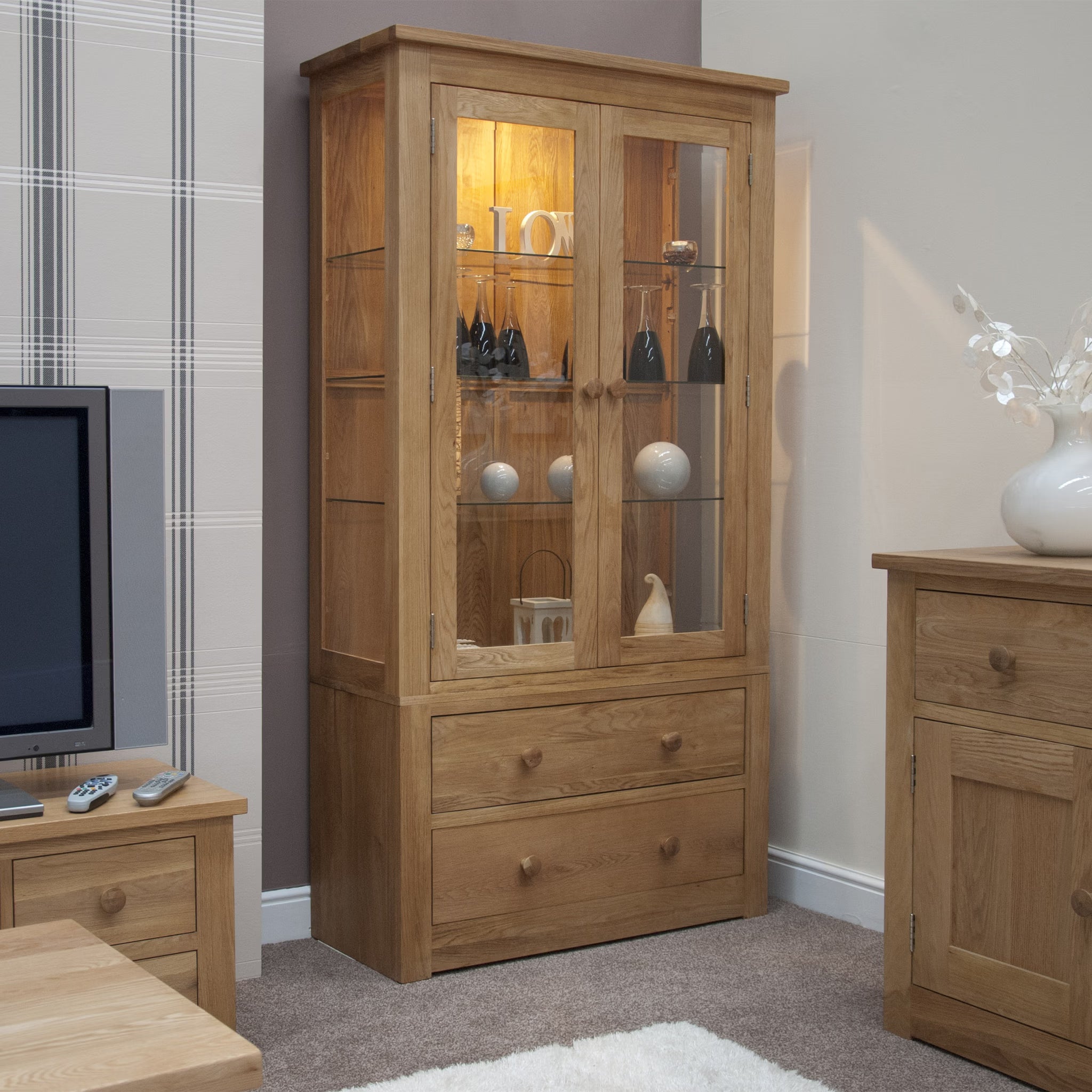Oak display cabinet with glass doors and drawers in living room setting
