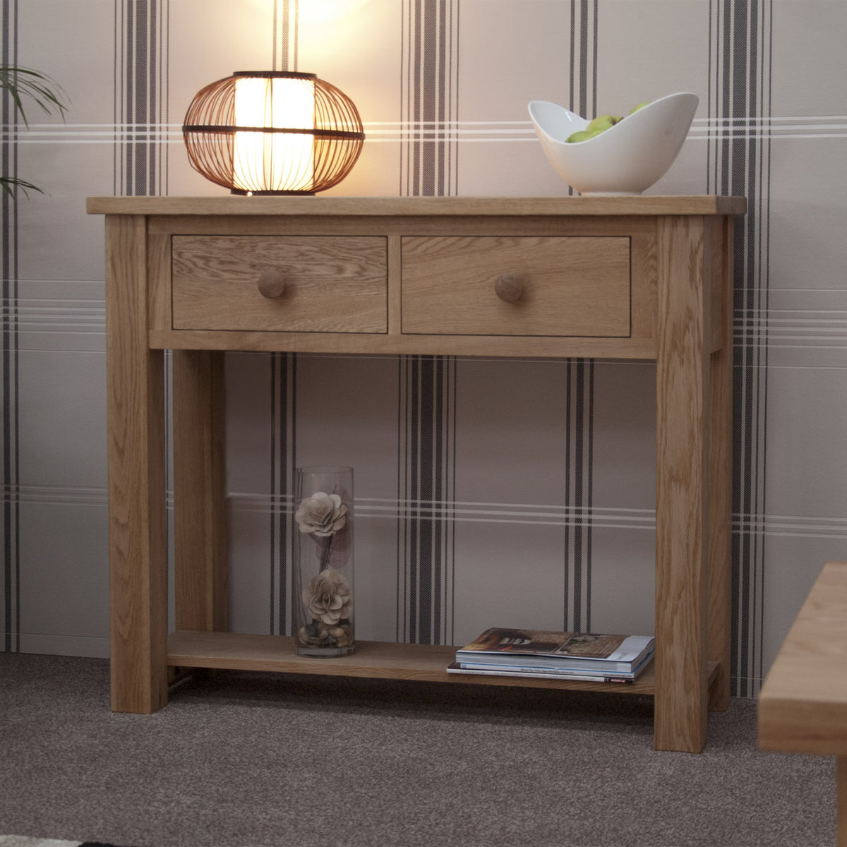 Oak console table with two drawers, shelf, lamp and bowl in living room setting