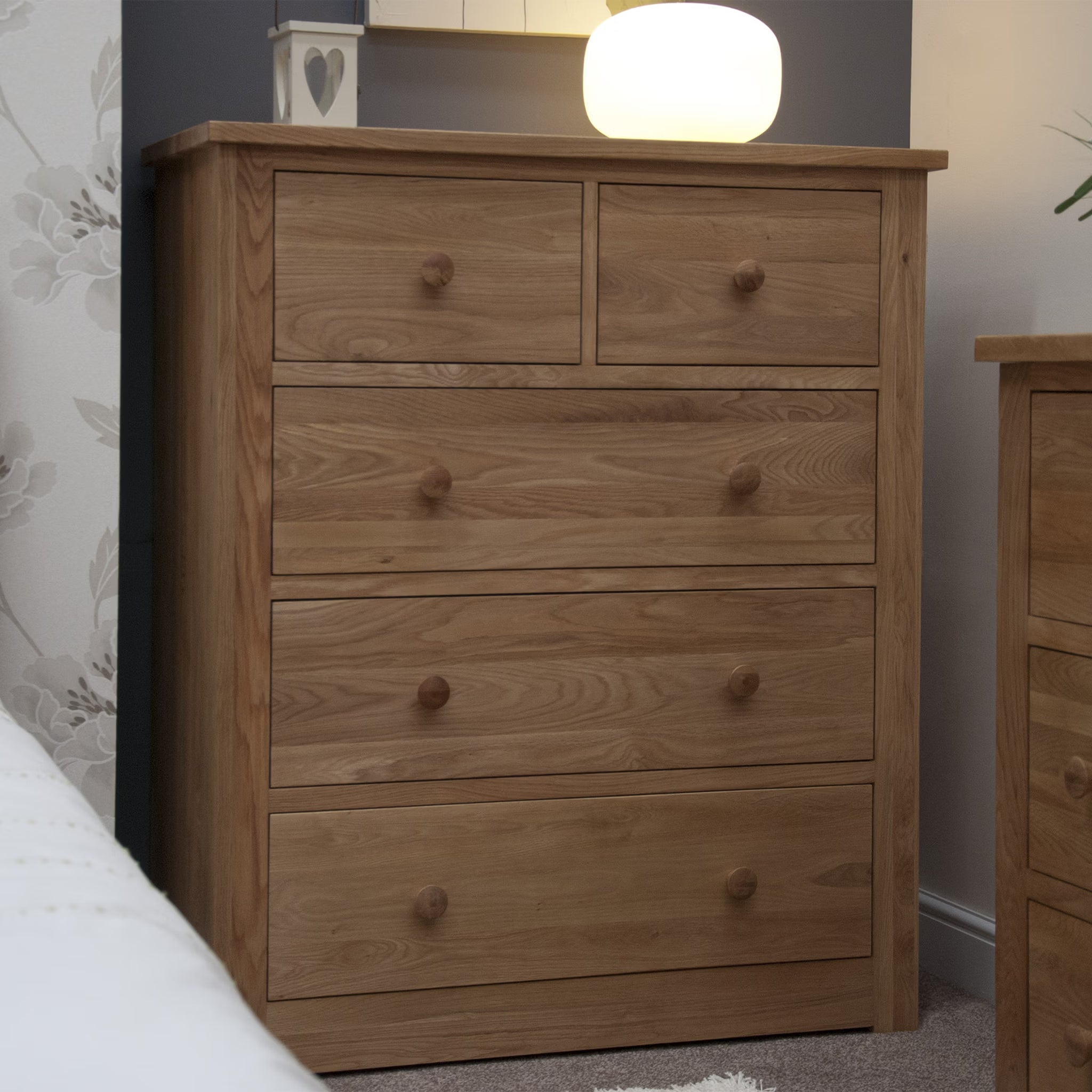 Oak chest of drawers with five drawers in bedroom setting