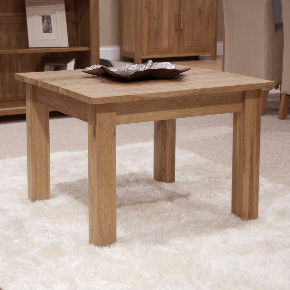 Oak coffee table with straight legs on a white rug in living room setting