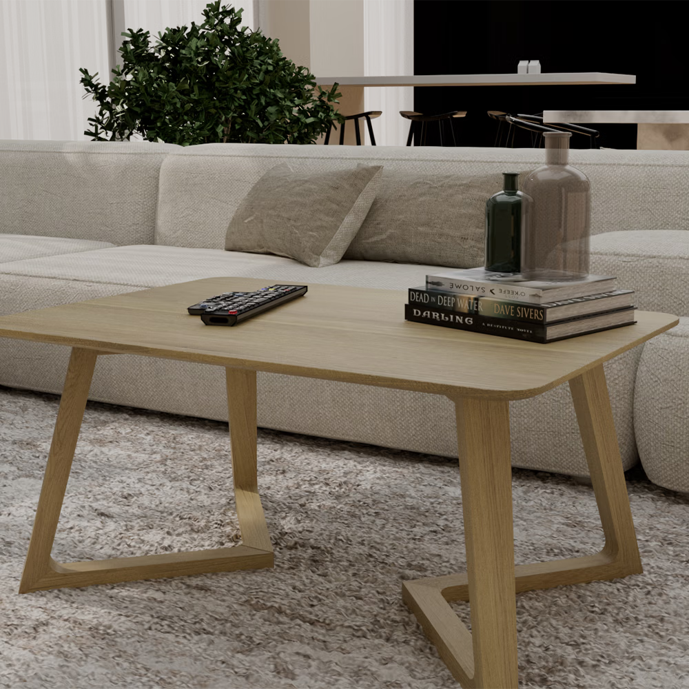 Light oak coffee table with books, vases, and remote on textured rug in modern living room