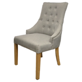 Light grey fabric dining chair with button tufted backrest and wooden legs
