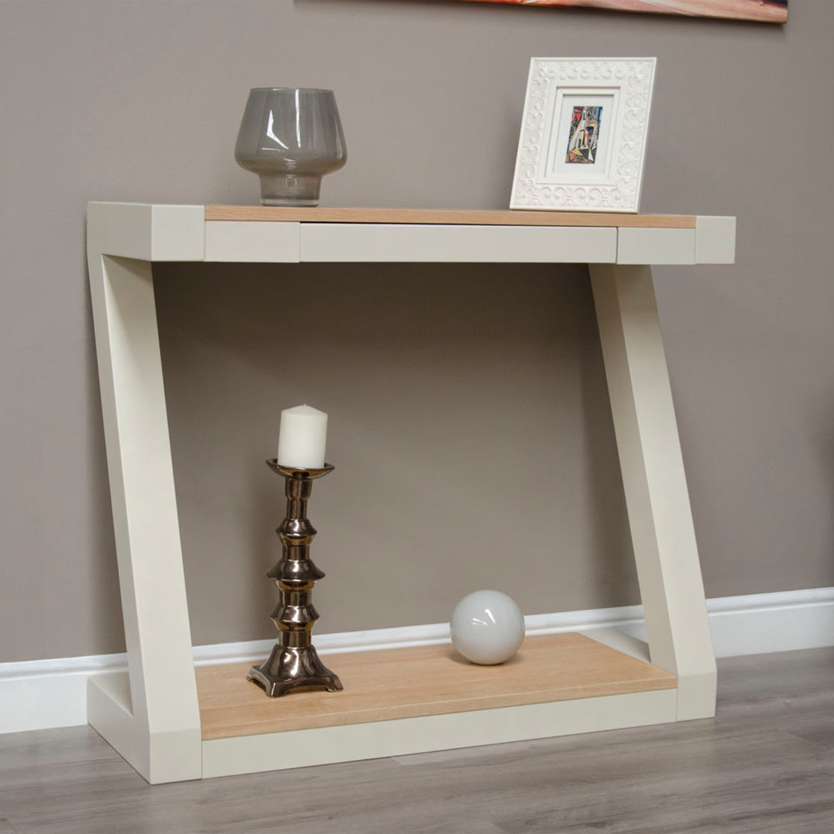 Modern cream and oak console table with glass vase, framed photo, candle, and decor ball