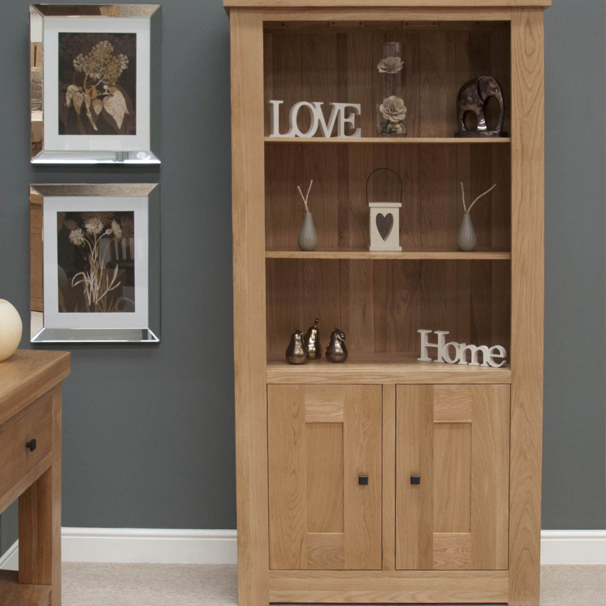 Oak display cabinet with shelves and storage doors, styled with decorative home accessories