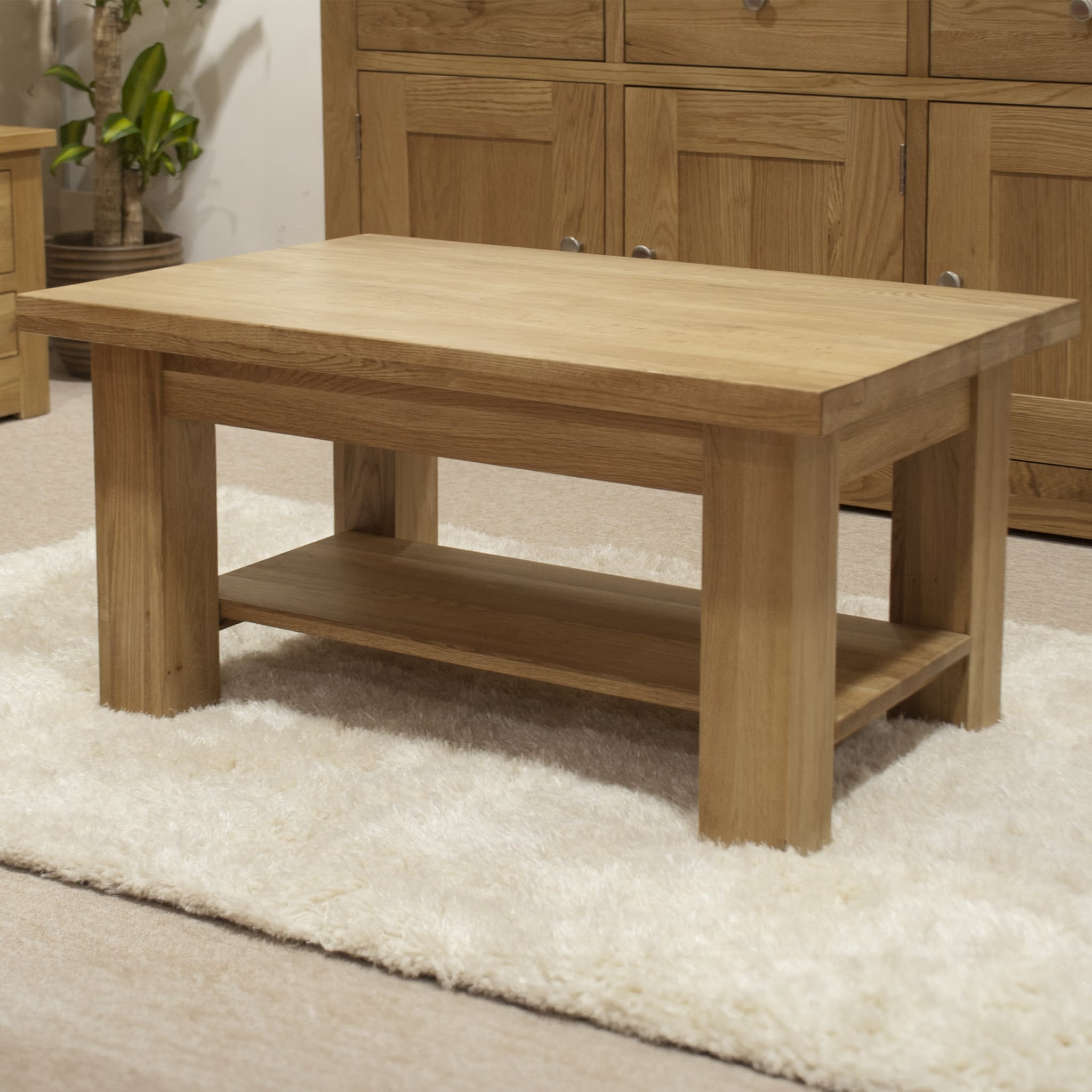 Oak coffee table with lower shelf on cream rug in living room setting