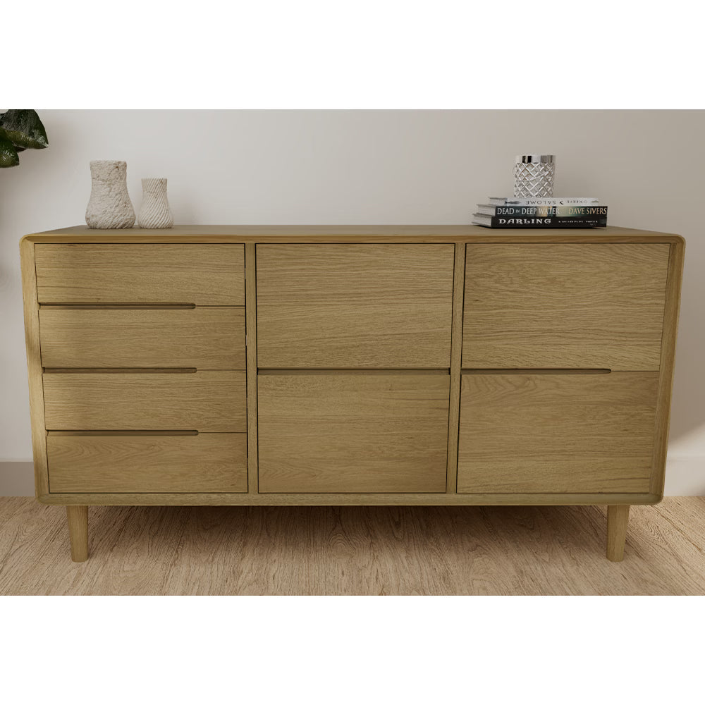 Oak sideboard with three drawers and four cupboard doors, styled with vases and books